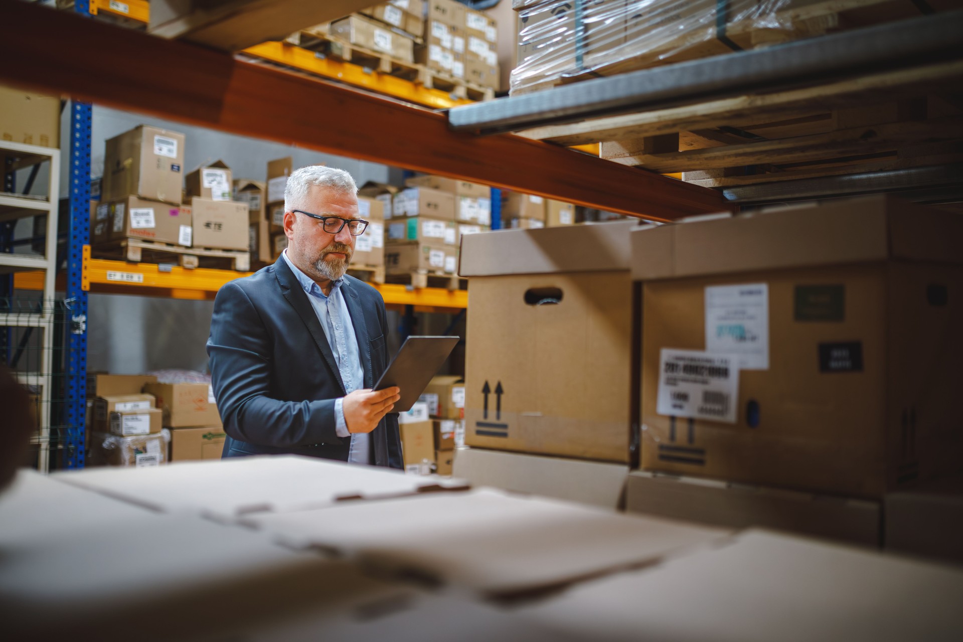 Factory manager using a digital tablet in a warehouse